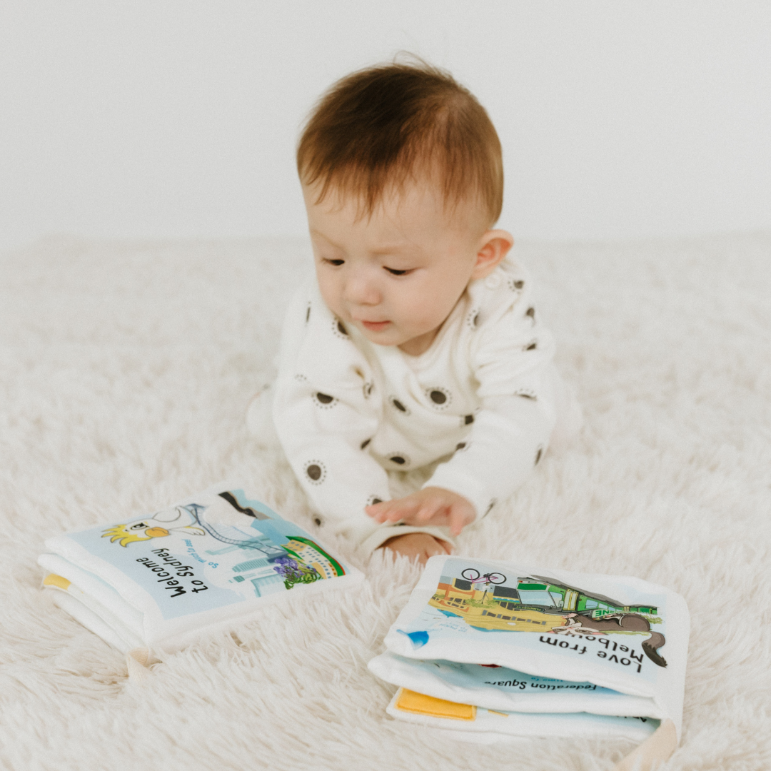 Baby boy playing with baby soft book