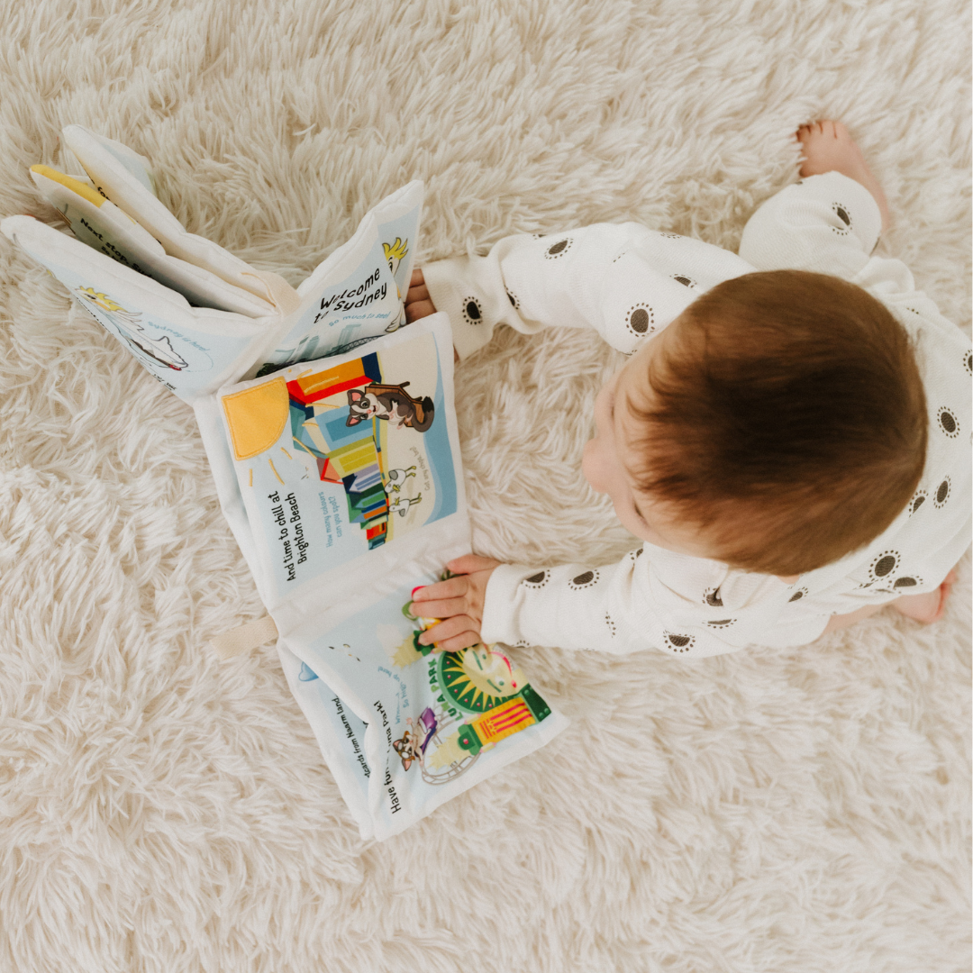 Baby boy playing with baby soft book