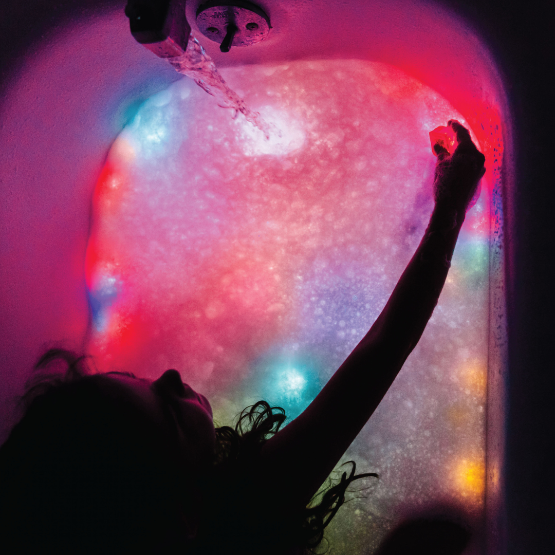 Girl playing with light up cubes in the bath