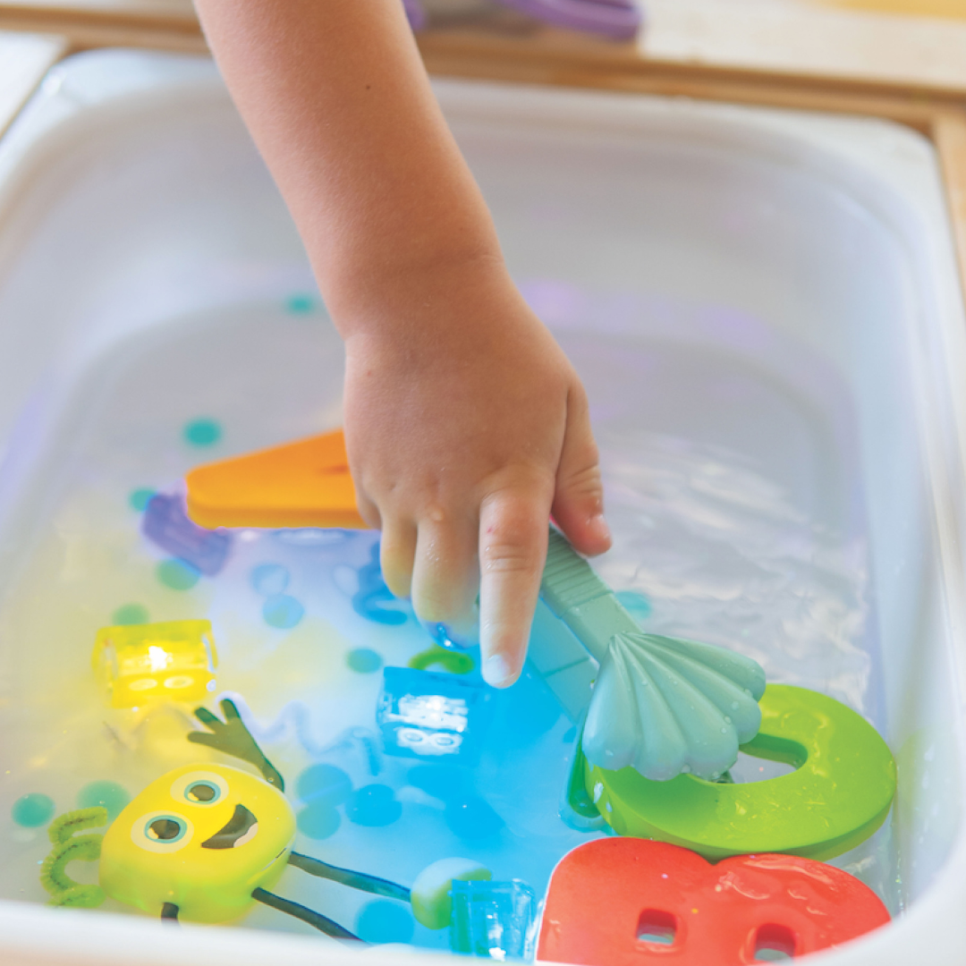 Close of child's hand holding blue tongs