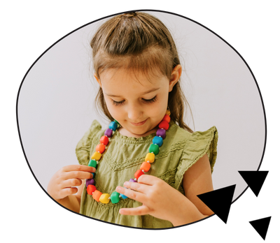 Girl playing with rainbow silicone chew necklace