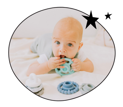 Baby boy chewing on stacking toy