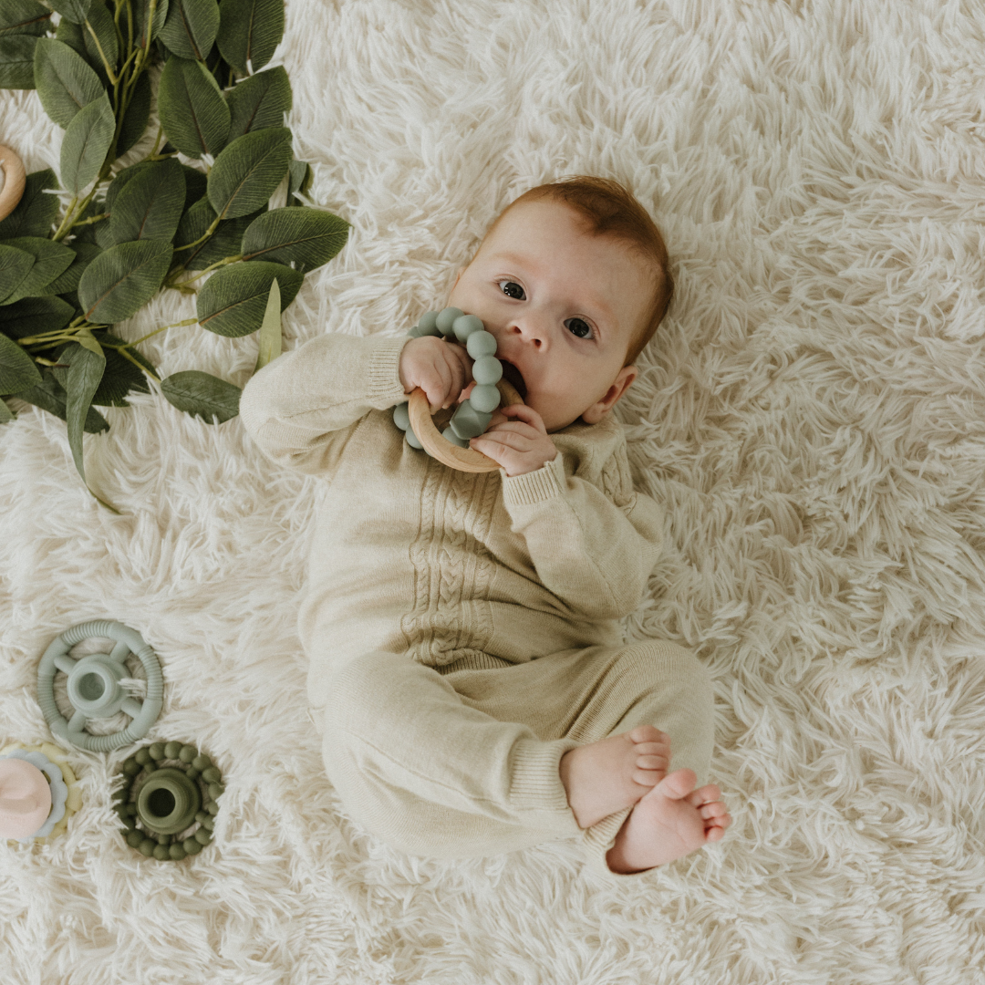 Baby boy chewing on May Gibbs moon teether