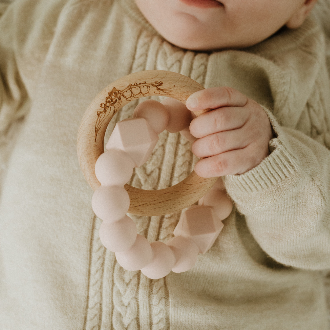 Baby holding May Gibbs moon teether