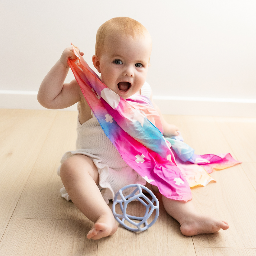 Baby playing with rainbow playsilk