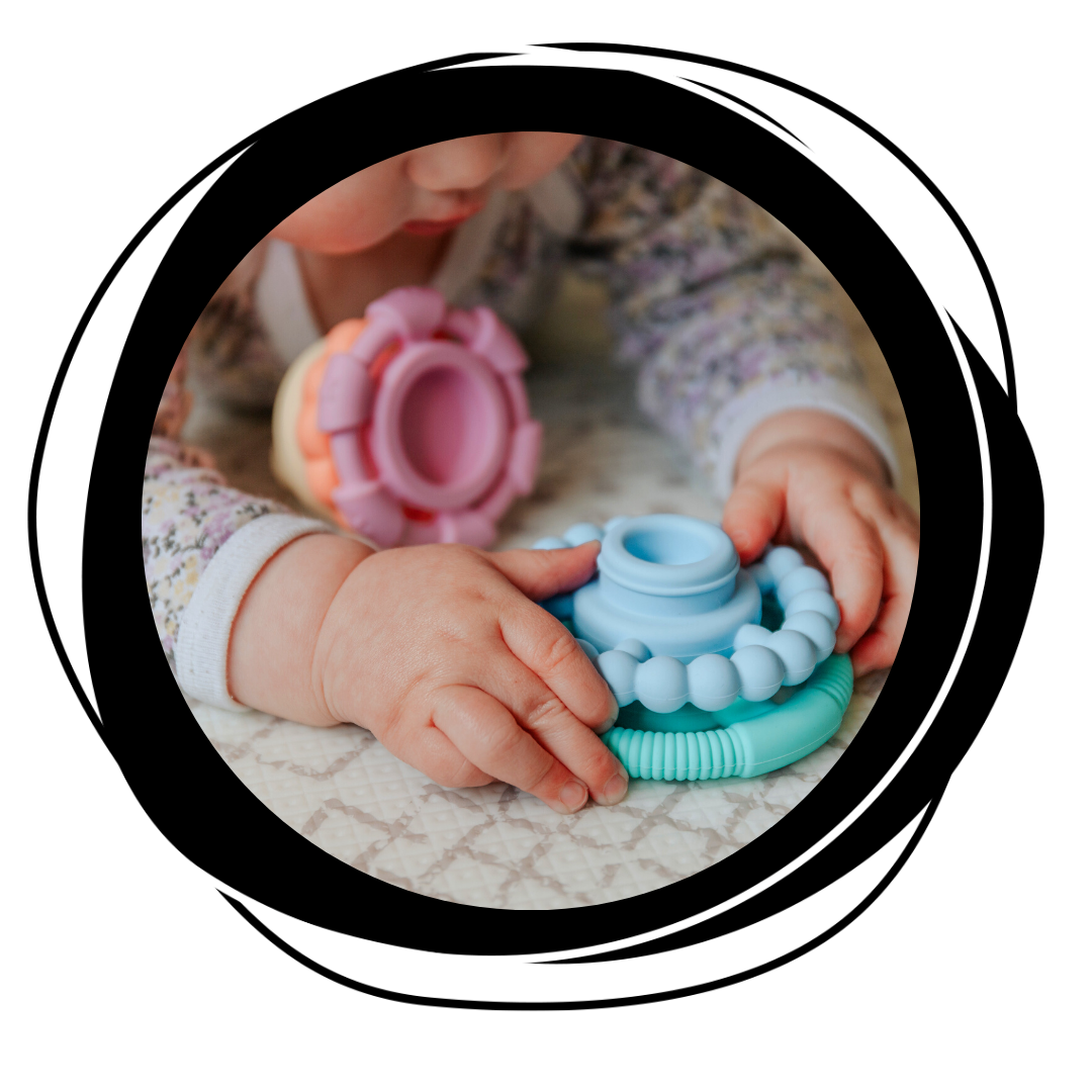 Girl playing with Rainbow Stacker and Teether Toy