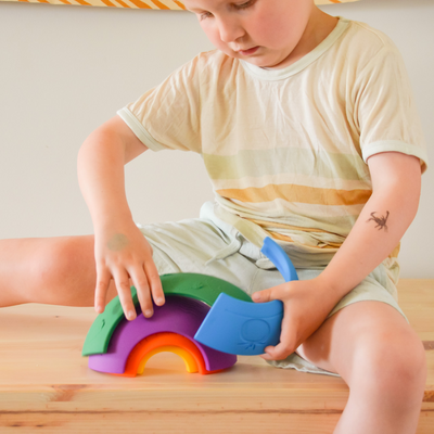 Boy playing with silicone rainbow toy