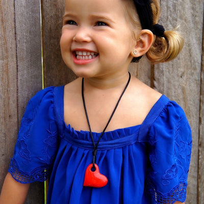 Girl wearing heart pendant.