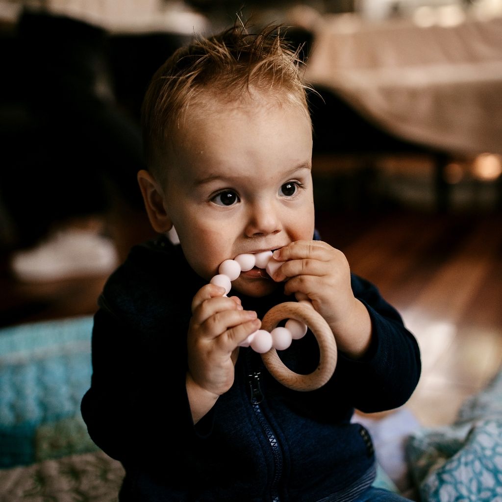 Baby boy chewing moon teether