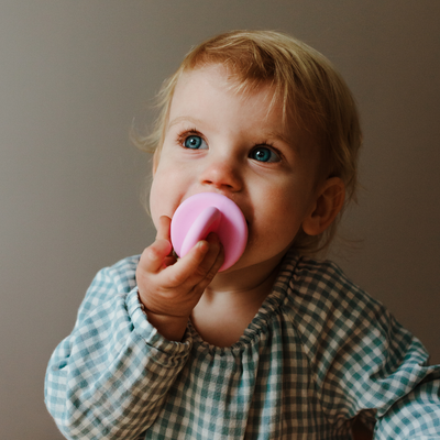 Girl chewing on pink silicone top