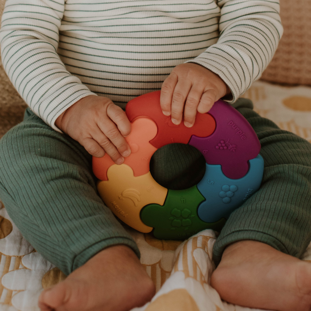 Baby holding a rainbow colour wheel
