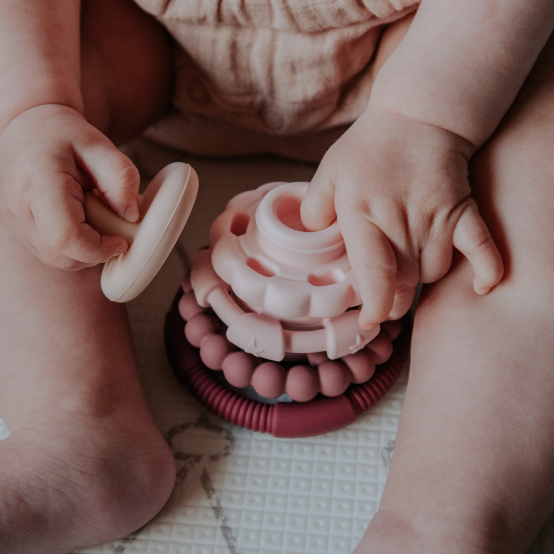 Girl playing with dusty pink stacker