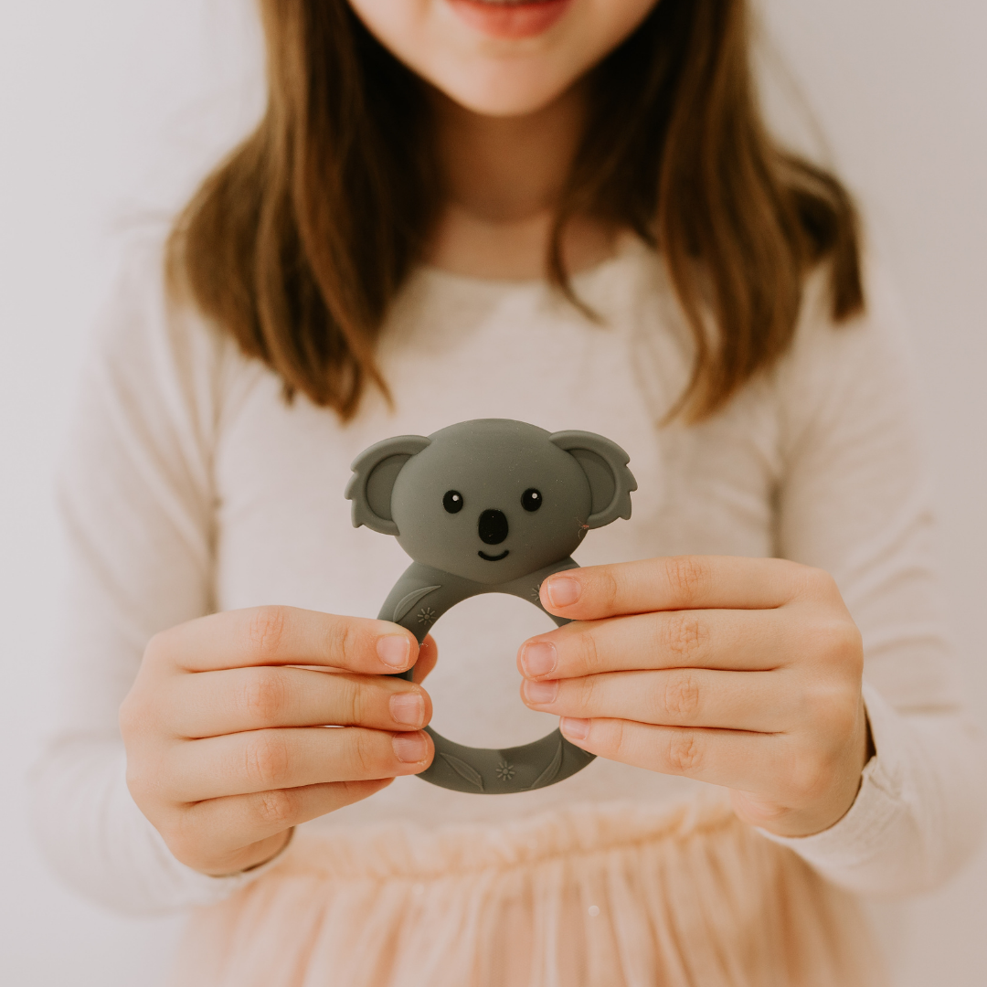 Girl holding a koala silicone teether