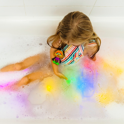 Girl with light up cubes in the bath