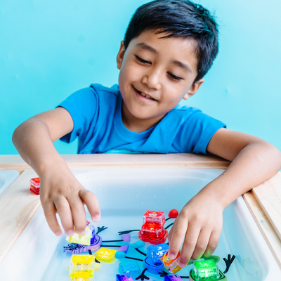 Boy playing with glo pals in a sensory tray