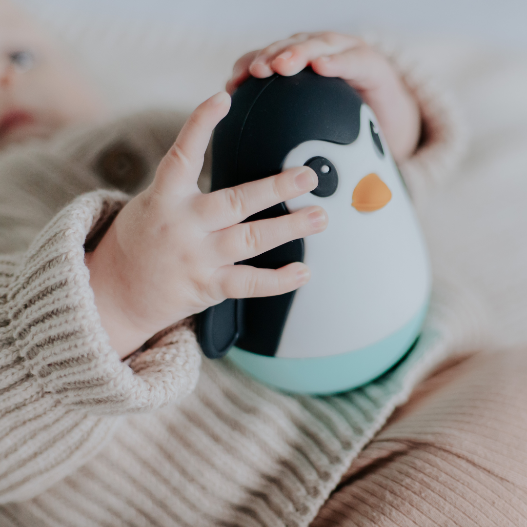Baby holding penguin wobble toy