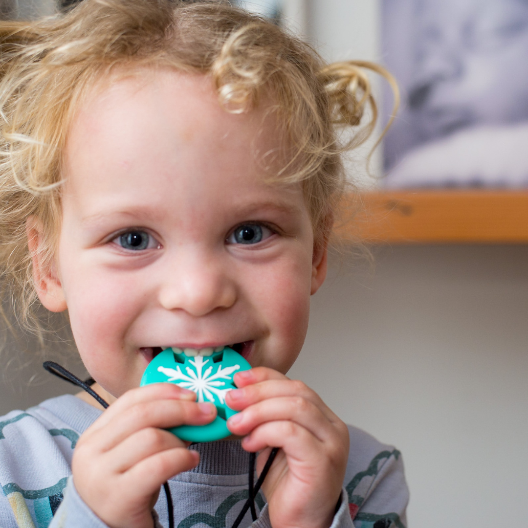 Girl chewing on a silicone necklace
