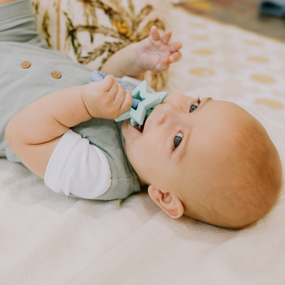 Close up of boy chewing on a star teether