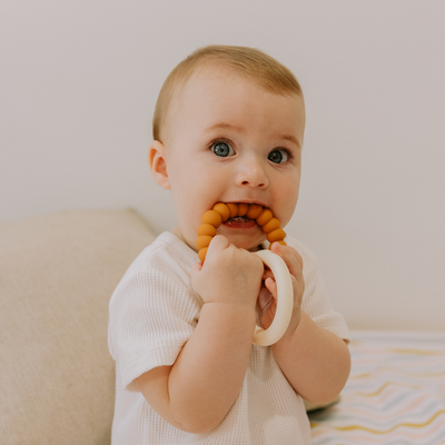 Boy chewing on sunshine teether