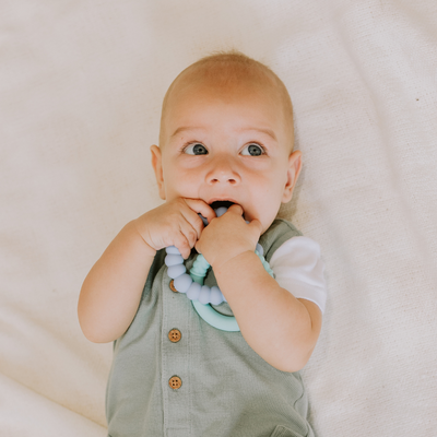 Boy chewing on blue teether